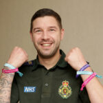 Stuart in uniform showing charity wristbands