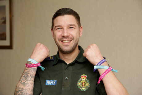 Stuart in uniform showing charity wristbands