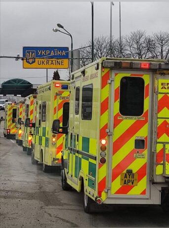 London Ambulances crossing the border to Ukraine image shows five of the ambulances approaching the Ukraine border sign