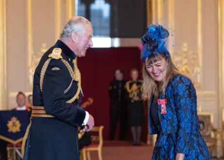 Amanda Mansfield laughing and sharing a joke with Prince Charles as he presents her MBE at Windsor Castle