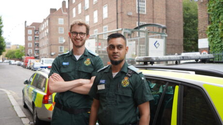 ER volunteer Ali with cremate in front of emergency response cars