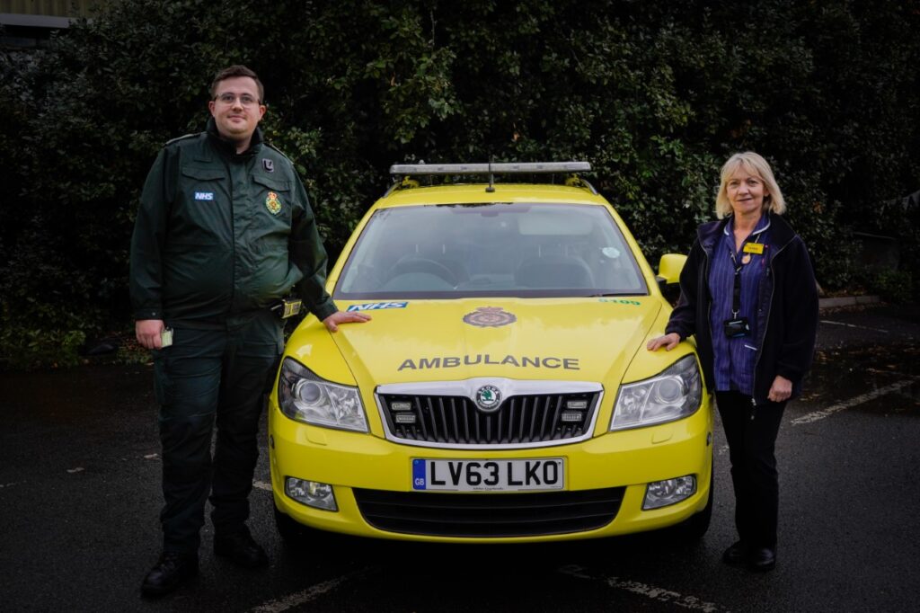 A London Ambulance Service paramedic teaming up with a community nurse, standing next to an Urgent Community Response Car.