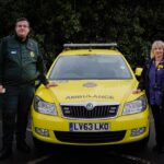 A London Ambulance Service paramedic teaming up with a community nurse, standing next to an Urgent Community Response Car.