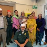 A picture of Ron Dhesi, LAS colleague Lucinda, his family and community leaders, standing by the Woolwich Gurdwara defibrillator.