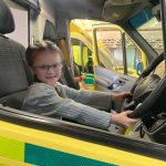 A picture of Cali-Maii in a London Ambulance vehicle pretending to drive it.