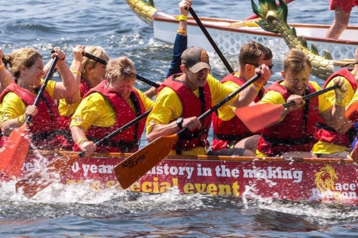 Image shows a group of people rowing in a dragon boat race.