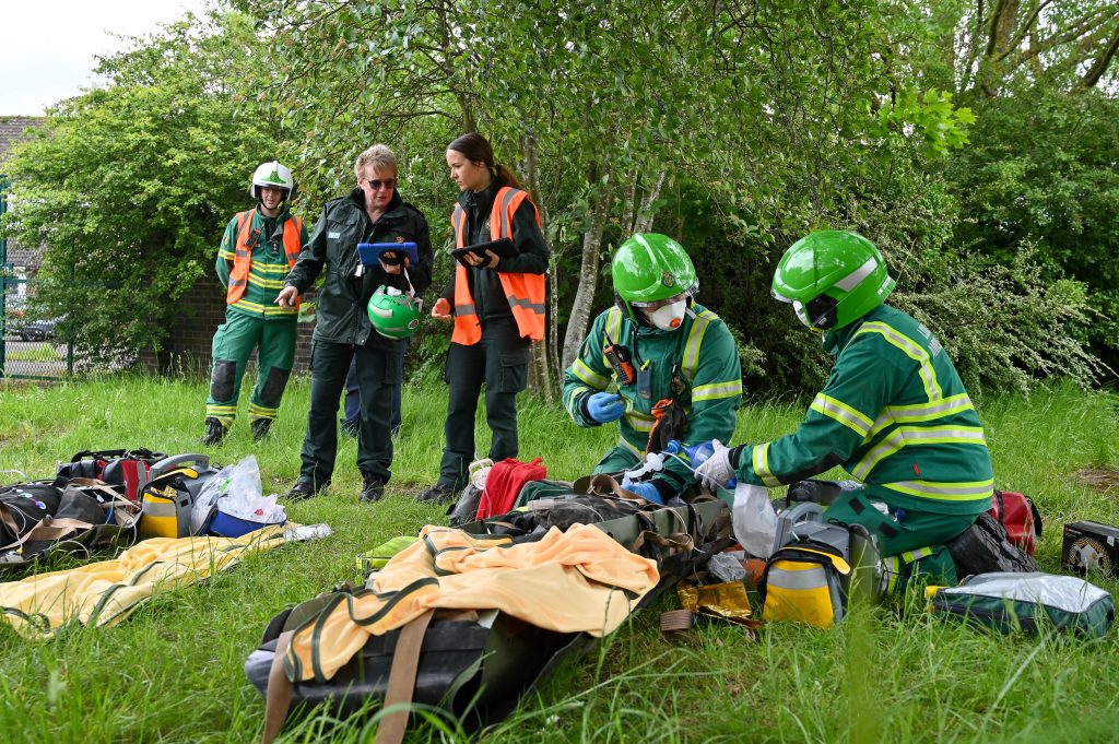 Pauline at a Hazardous Area Response Team training session, holding an iPad and speaking to colleagues.