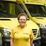 Carolyn standing in front of ambulances