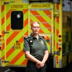 Paramedic Ella Johnson standing in front of an ambulance
